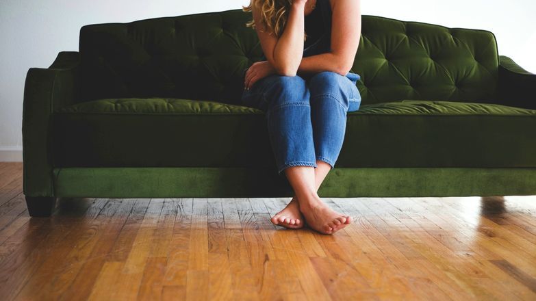 Woman sat of a green sofa