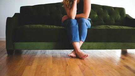 Woman sat of a green sofa