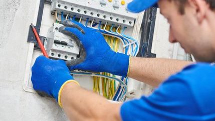 Electrician working on fuse box