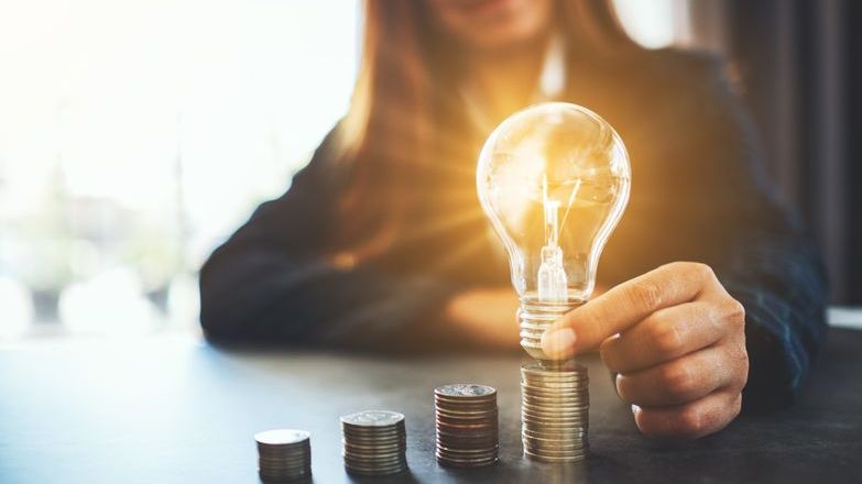 Lightbulb lit up by coins