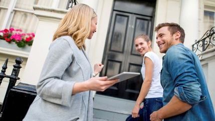 Couple walking up steps to view a property